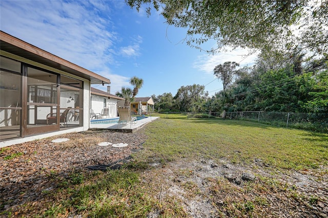 view of yard with a fenced in pool, a patio area, and a sunroom