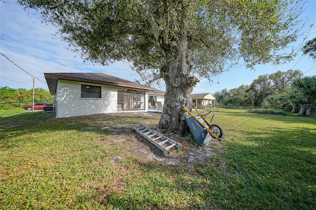 back of house with a yard and a sunroom