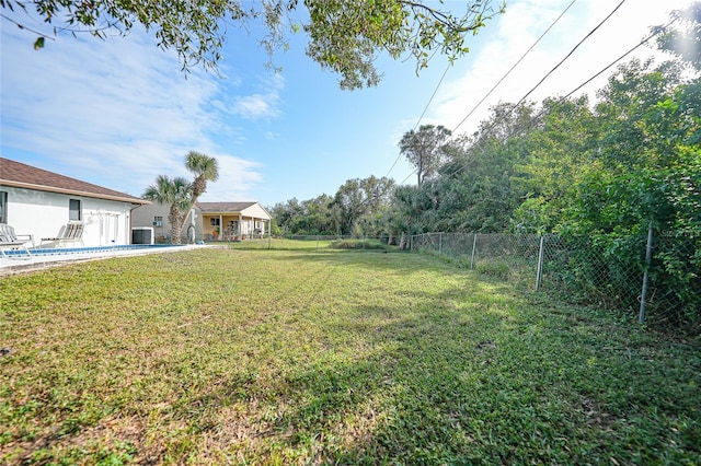 view of yard with a swimming pool and central air condition unit