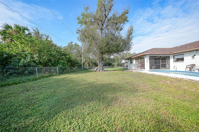 view of yard featuring a fenced in pool and a sunroom