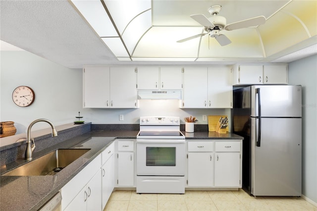 kitchen with appliances with stainless steel finishes, white cabinetry, light tile patterned floors, sink, and ceiling fan