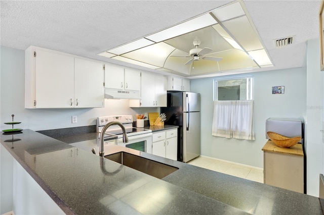 kitchen with white range with electric cooktop, kitchen peninsula, sink, white cabinetry, and stainless steel refrigerator