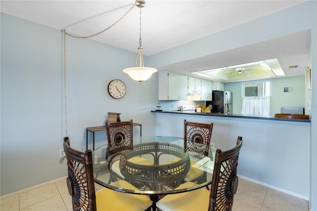 tiled dining space with ceiling fan