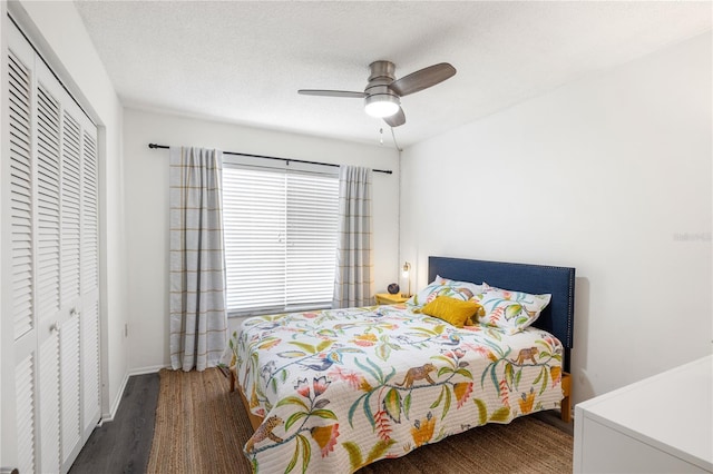 bedroom with a closet, ceiling fan, dark wood-type flooring, and a textured ceiling