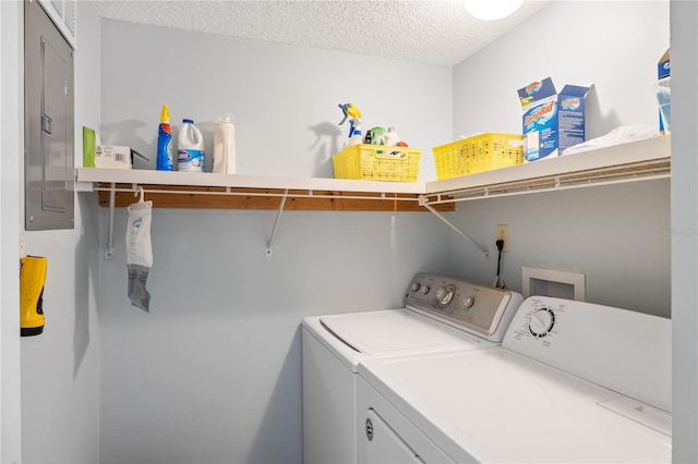 laundry area with independent washer and dryer, electric panel, and a textured ceiling