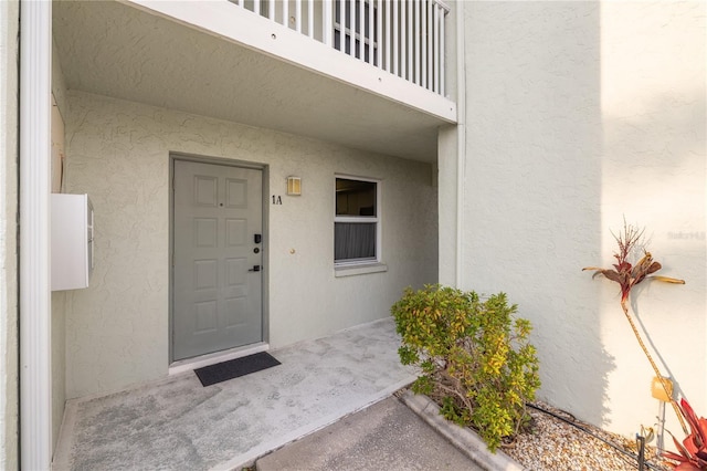 view of exterior entry featuring a balcony