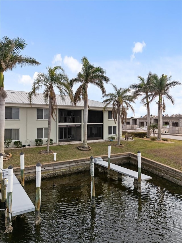 view of dock featuring a lawn and a water view