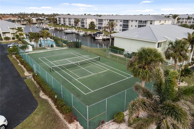 view of tennis court featuring a water view