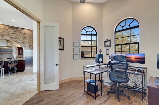 office space featuring a high ceiling and light wood-type flooring