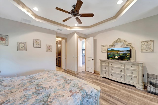 bedroom featuring a raised ceiling, crown molding, ceiling fan, and light hardwood / wood-style floors