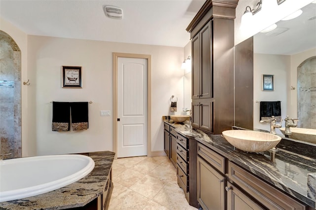 bathroom with vanity, a washtub, and tile patterned floors