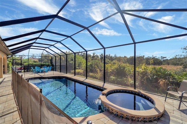 view of swimming pool featuring an in ground hot tub, a patio area, and glass enclosure