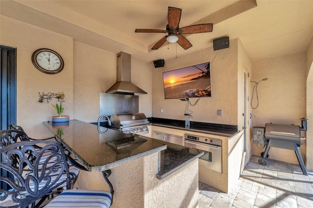 view of patio / terrace with ceiling fan, a grill, and exterior kitchen