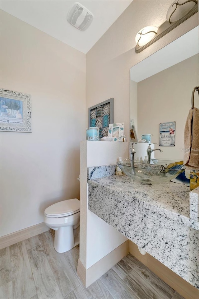 bathroom featuring wood-type flooring, sink, and toilet