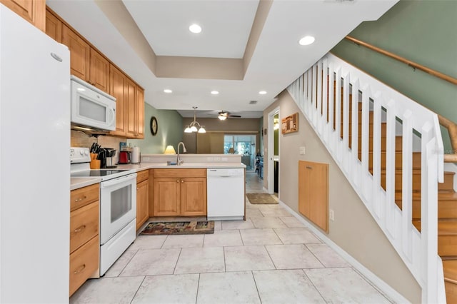 kitchen featuring sink, light tile patterned floors, white appliances, decorative light fixtures, and kitchen peninsula