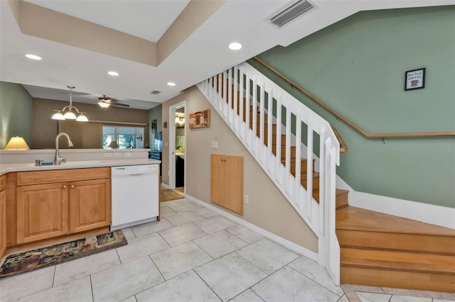 kitchen featuring light tile patterned flooring, sink, white dishwasher, pendant lighting, and ceiling fan with notable chandelier