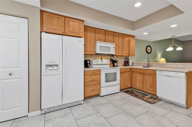 kitchen featuring sink, an inviting chandelier, hanging light fixtures, white appliances, and backsplash