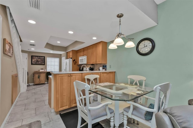 dining room featuring a tray ceiling and sink