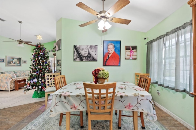 tiled dining room with lofted ceiling and ceiling fan