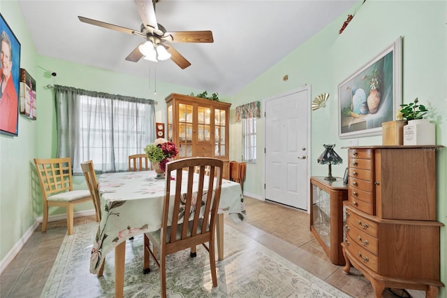 dining area with ceiling fan, vaulted ceiling, and light tile patterned floors