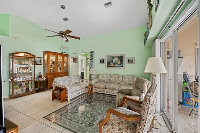 living room with ceiling fan, vaulted ceiling, and light tile patterned floors