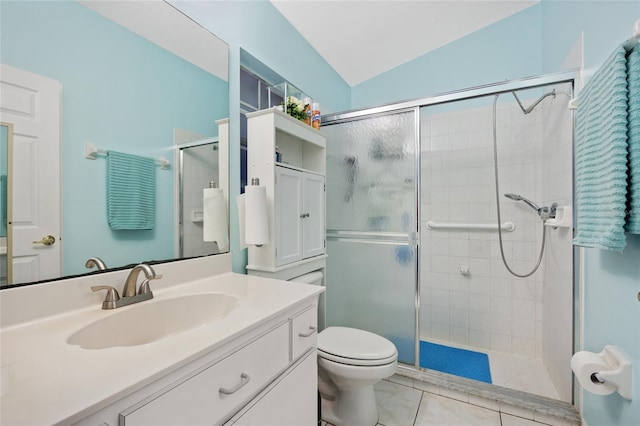 bathroom featuring a shower with door, vanity, tile patterned flooring, and toilet