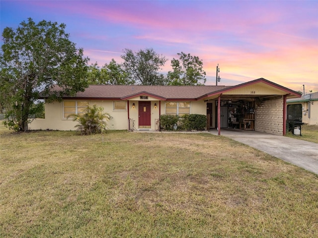 ranch-style home featuring a carport and a lawn