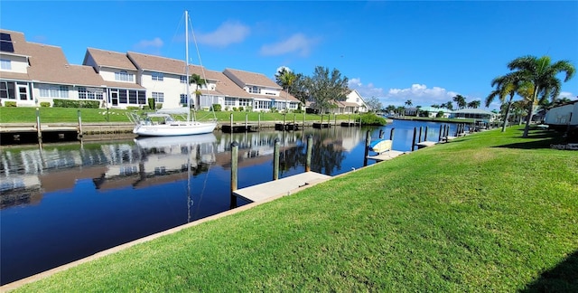 dock area with a lawn and a water view