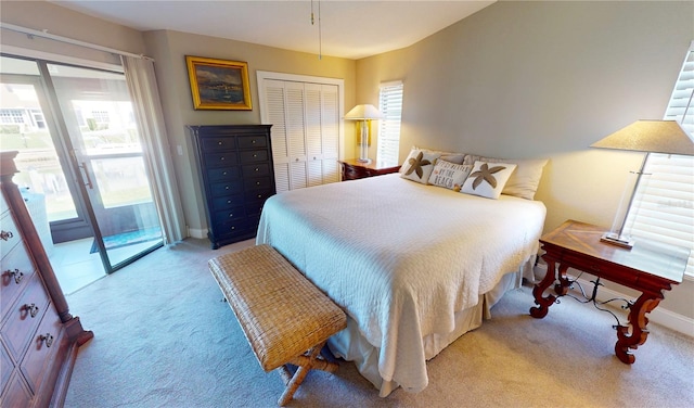 bedroom featuring light carpet, access to outside, and a closet