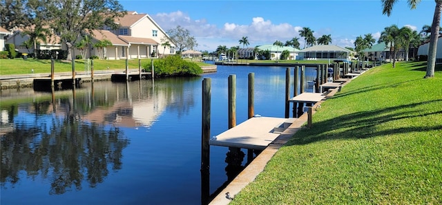 view of dock featuring a lawn and a water view