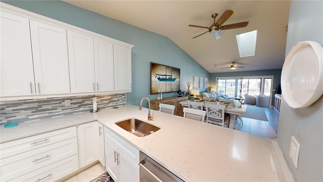 kitchen featuring tasteful backsplash, sink, kitchen peninsula, and white cabinets