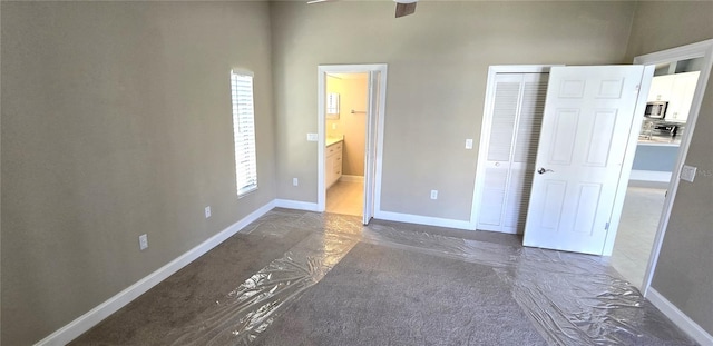 unfurnished bedroom with connected bathroom and a closet