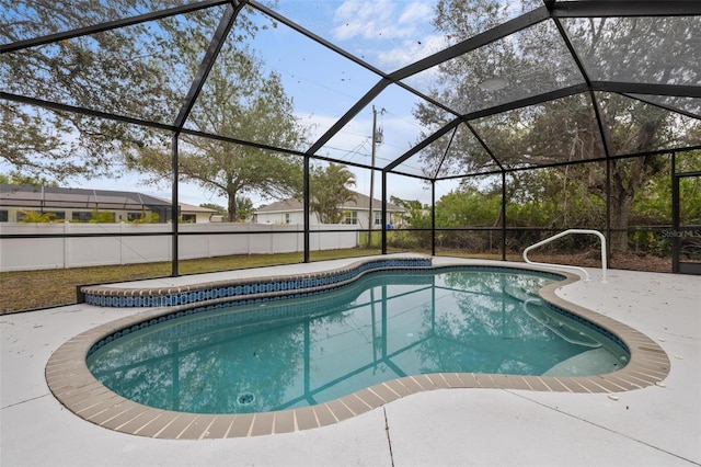 view of pool with glass enclosure and a patio area