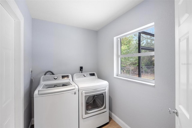 laundry room featuring light hardwood / wood-style flooring and washing machine and dryer