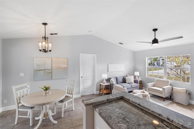 living area featuring lofted ceiling, light tile patterned floors, visible vents, and ceiling fan with notable chandelier