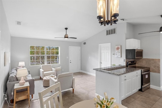 kitchen with visible vents, appliances with stainless steel finishes, white cabinetry, dark stone counters, and ceiling fan with notable chandelier