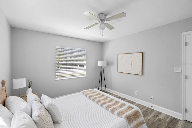 bedroom with a ceiling fan, baseboards, and wood finished floors