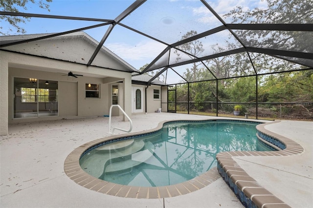 pool featuring a patio, glass enclosure, and a ceiling fan