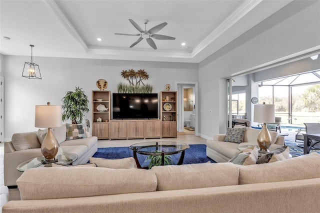 living room with a ceiling fan, a sunroom, a tray ceiling, crown molding, and recessed lighting