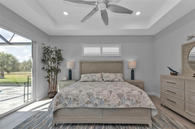 bedroom with access to exterior, baseboards, a tray ceiling, and recessed lighting