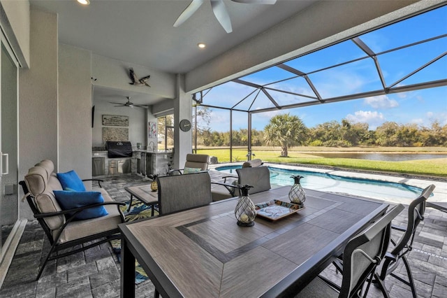 view of patio / terrace with ceiling fan, an outdoor kitchen, a lanai, a grill, and outdoor dining space