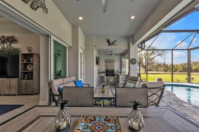 exterior space featuring an outdoor hangout area, ceiling fan, exterior kitchen, a lanai, and an outdoor pool