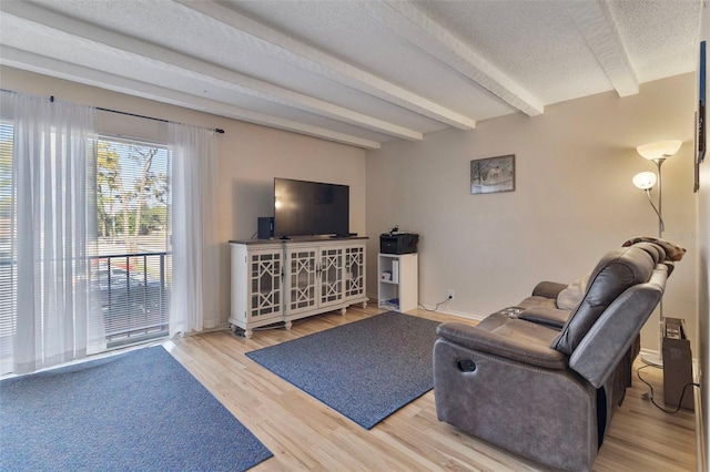 living room featuring beam ceiling and light hardwood / wood-style floors