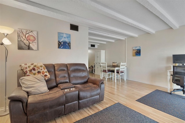 living room featuring wood-type flooring and beamed ceiling