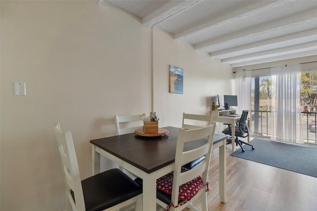 dining space with beam ceiling and wood-type flooring