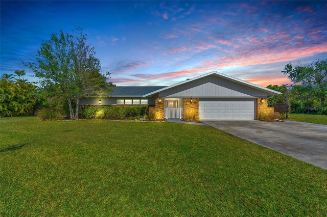 ranch-style house with a garage and a yard