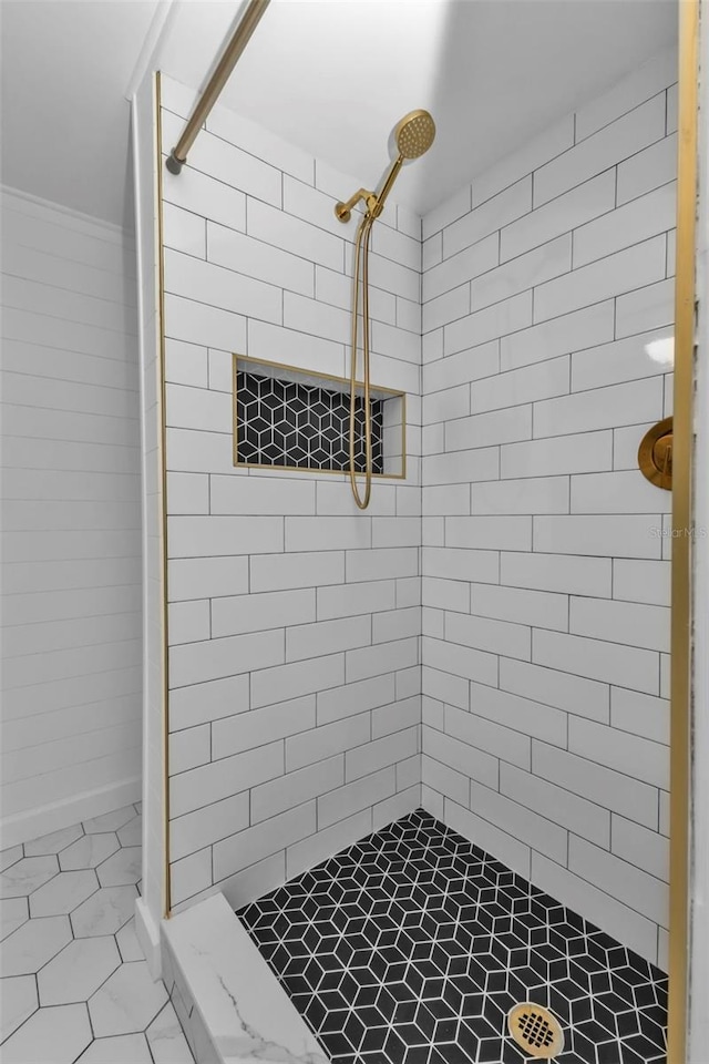 bathroom featuring tiled shower and ornamental molding