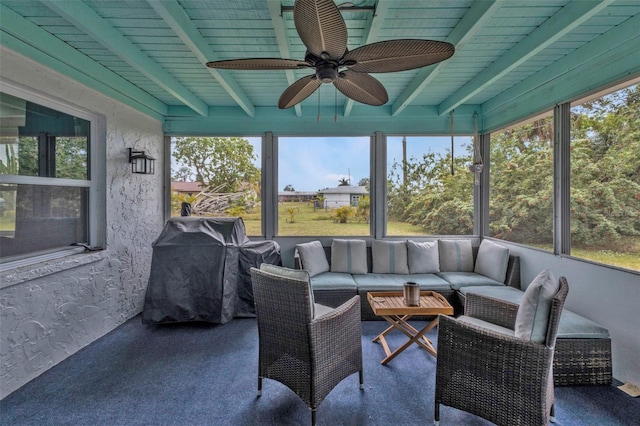 sunroom featuring beamed ceiling, a wealth of natural light, and ceiling fan