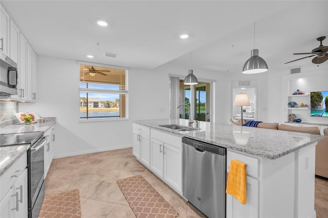 kitchen with pendant lighting, sink, stainless steel appliances, an island with sink, and white cabinets