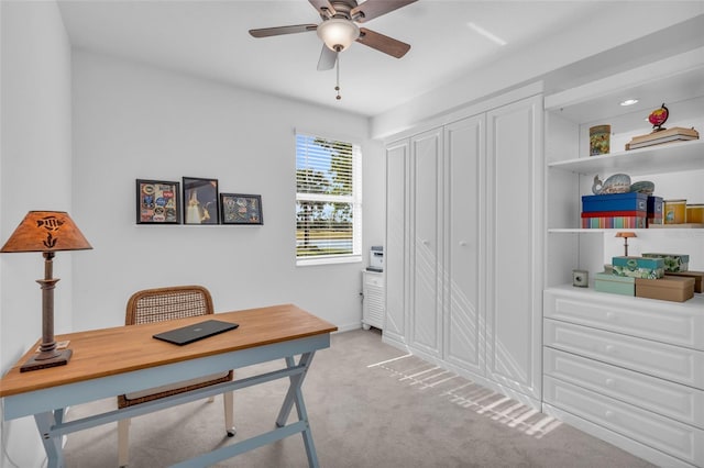 carpeted office space with ceiling fan